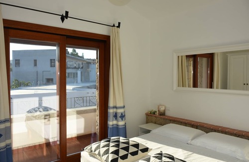 Lotzorai Apartment | Bedroom with double bed, veranda with view